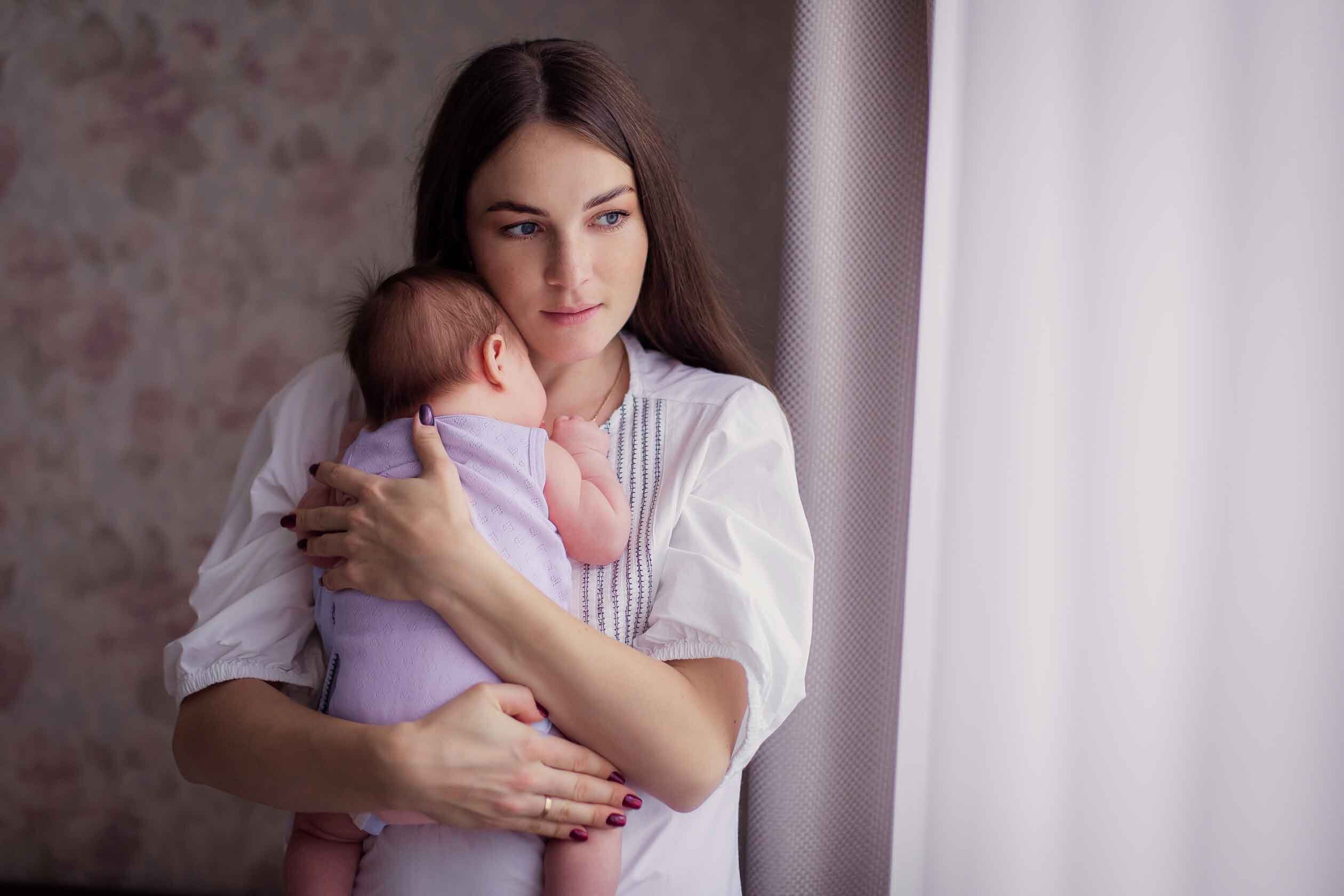 Mutter beruhigt ihr Baby auf dem Arm