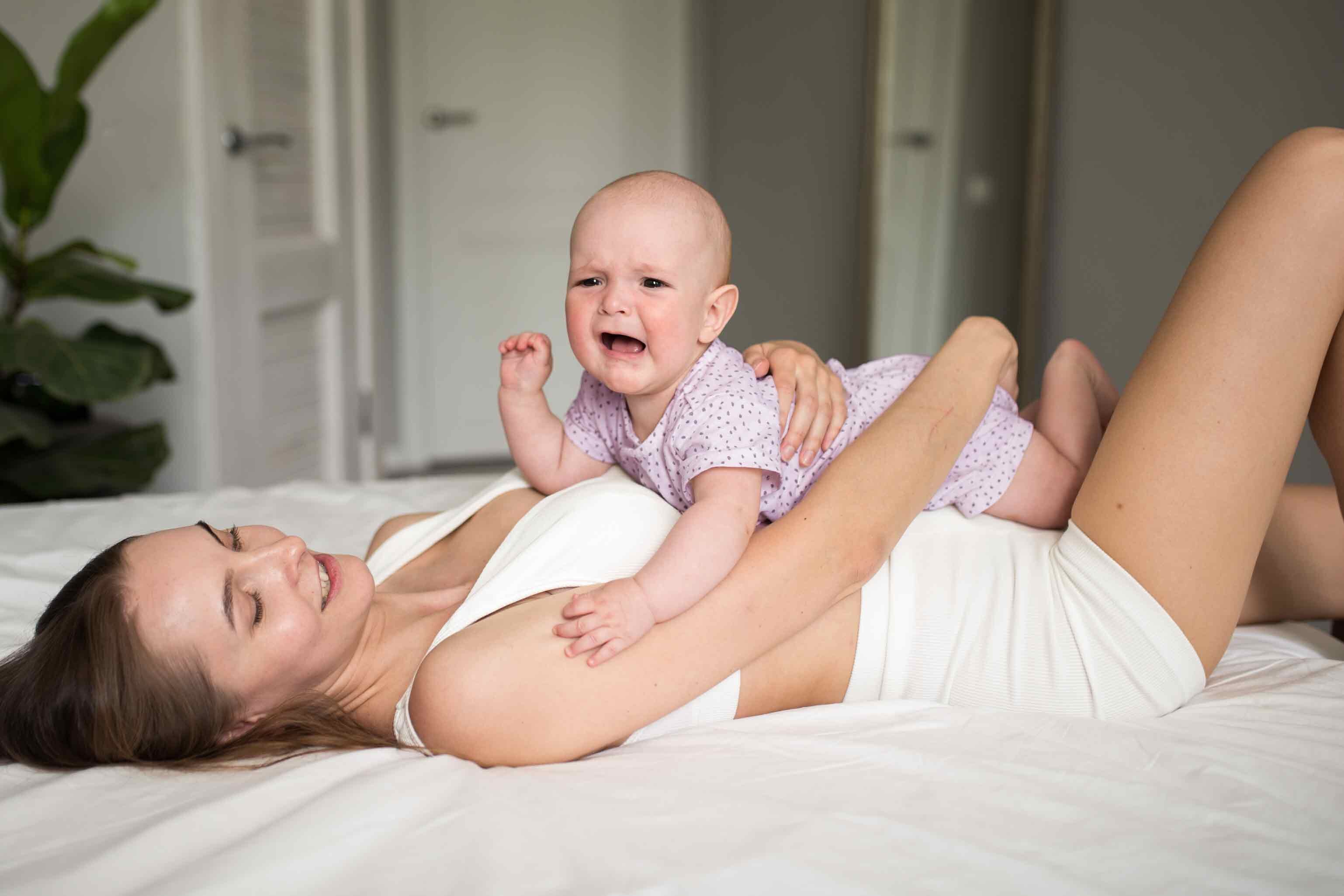 Schreiendes Baby liegt auf dem Bauch der Mutter