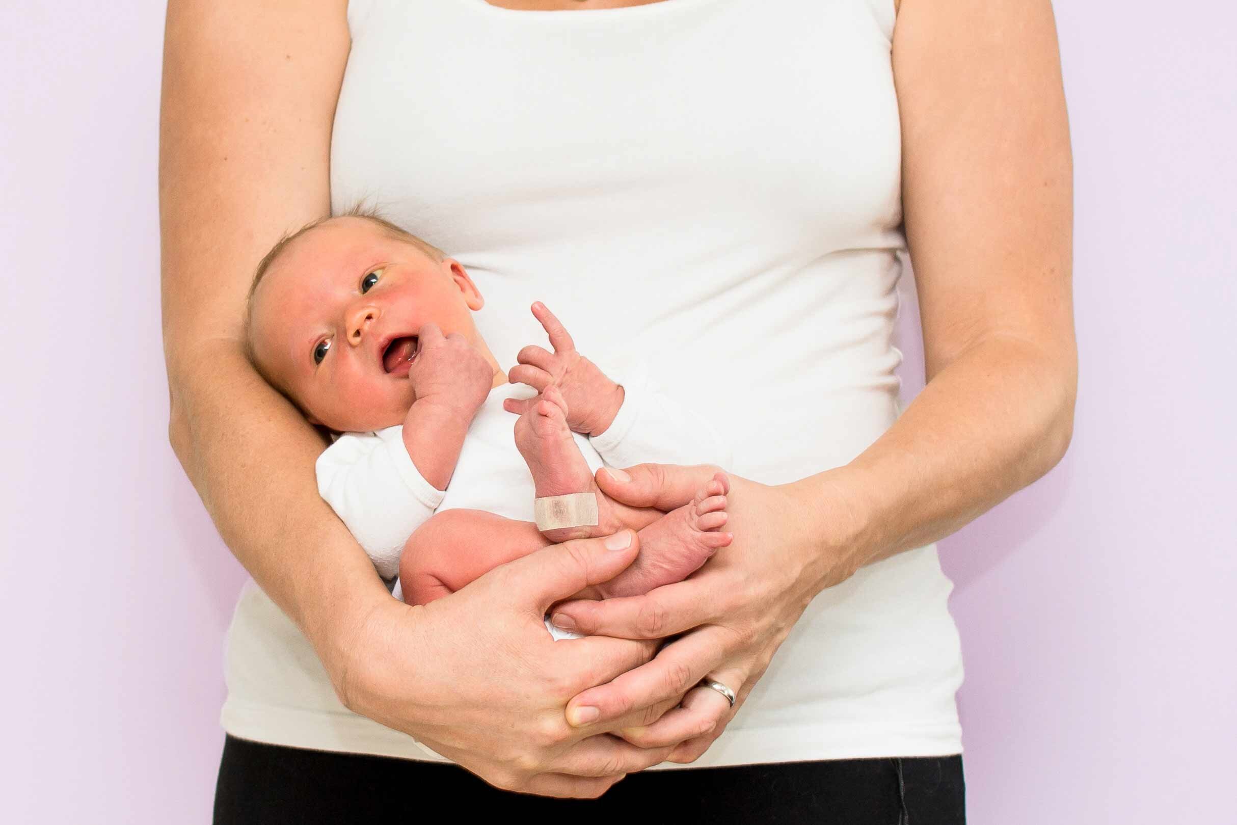 Neugeborenes mit Muttermilchikterus auf dem Arm seiner Mutter