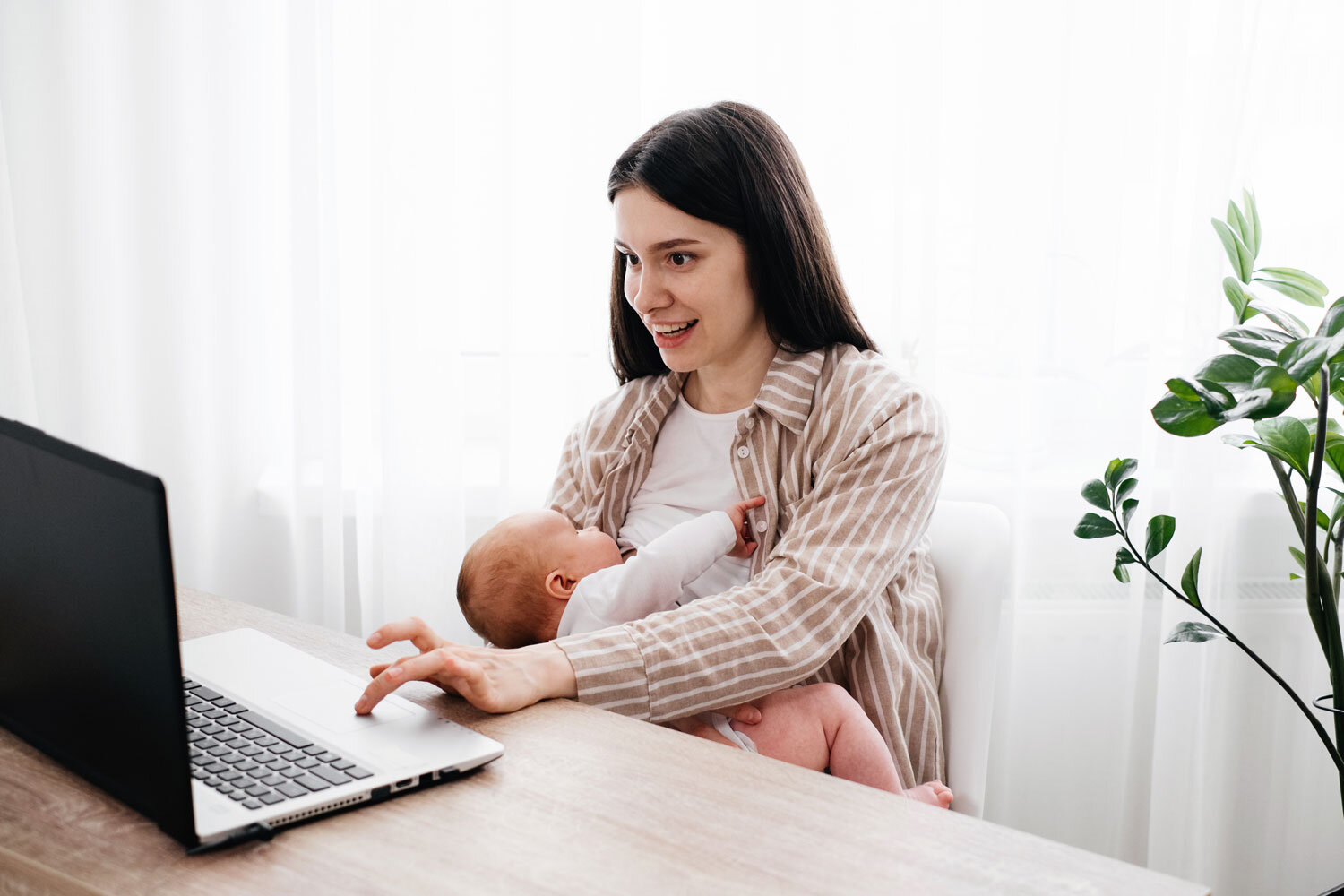 Mutter sitzt mit ihrem Baby im Büro