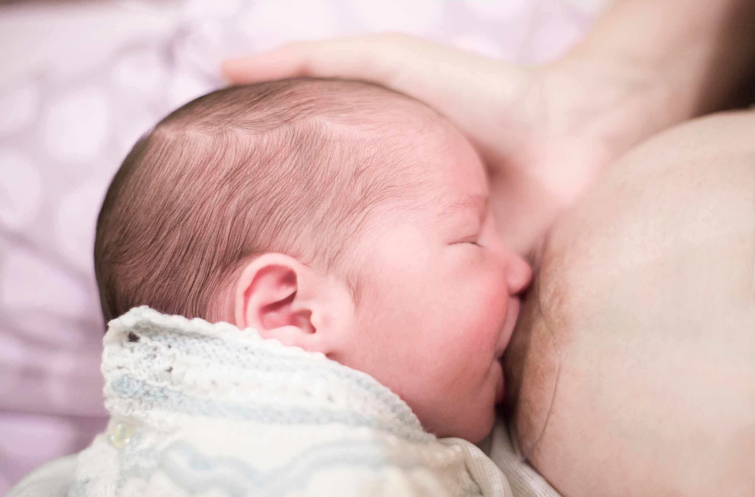 Baby wird unter Verwendung eines Brustwarzenformers gestillt